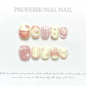 Detail of handmade press-on nails featuring hand-painted pig motifs and floral accents