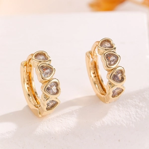Macro shot of 925 silver stamp on gold-plated hoop earrings with heart cubic zirconia