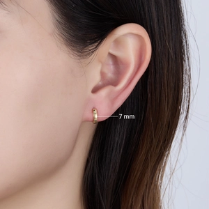 Close-up of 7mm minimalist gold hoop earrings showing scale on a model's ear