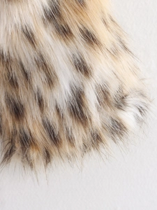 Close-up detail of soft faux fur texture with classic leopard print pattern