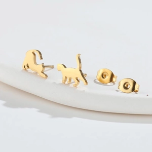 Minimalist golden cat earrings with stretching and walking poses on a white display