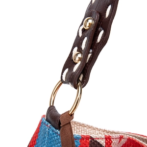 Detail of bohemian shoulder bag with brown leather strap and gold rivet accents