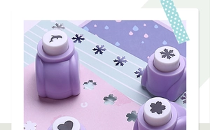 Close-up of mini purple craft puncher creating various decorative shapes on paper