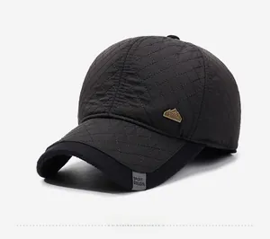 Close-up of quilted baseball cap with diamond pattern and mountain metal badge