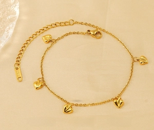Macro detail of 18K gold plated stainless steel heart charm bracelet with K18 tag
