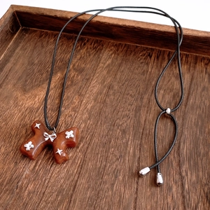 Detailed view of a vintage wooden bow pendant with silver stars on a retro tray
