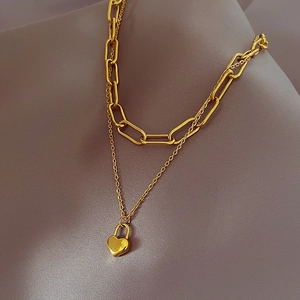 Double-layered gold titanium steel necklace featuring paperclip chain and heart lock charm
