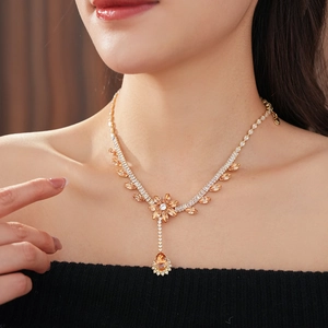 Detail of flower necklace with orange zircon drops on elegant model portrait