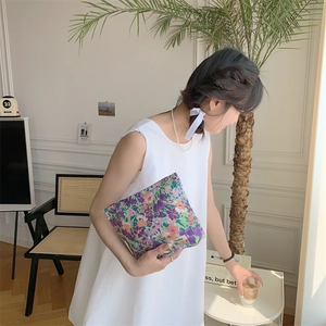Macro detail of purple floral cotton pouch with Sazakka brand label and fine fabric texture