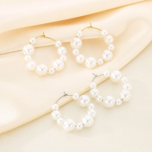 U-shaped stainless steel pearl hoop earrings in gold and silver set on silk