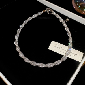 Detail view of twisted silver necklace with zircon in a premium jewelry gift box
