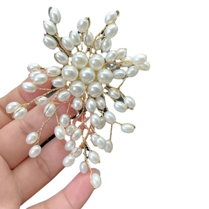 Handcrafted pearl brooch in white and gold featuring a radiant floral starburst design