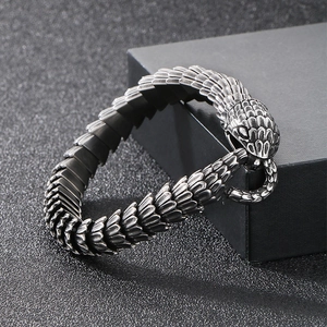 Gros plan sur la texture d'écailles de serpent et le fermoir tête sur bracelet en acier
