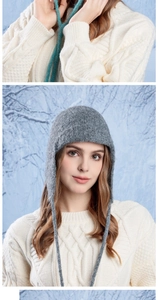 Detailed knit texture of a grey wool earflap beanie with braided ties for winter