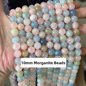 Detail of 10mm colorful Morganite beads held in hand showing polished finish