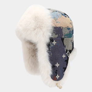 Detail of winter trapper hat showing white faux fur lining and jacquard star pattern