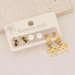 Detail of stainless steel earring set featuring gold elephant, zircon and bow charms