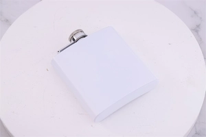 White stainless steel hip flask on a marble base with a metallic silver screw cap