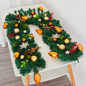 Close-up of a Christmas garland with pine cones, red berries, and golden star ornaments