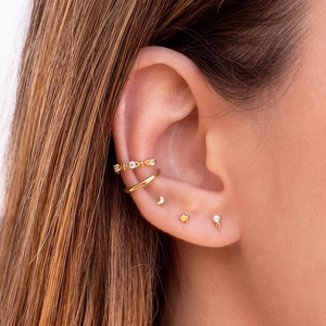 Detail of 5-piece gold earring set featuring crescent moon star and crystal stud designs