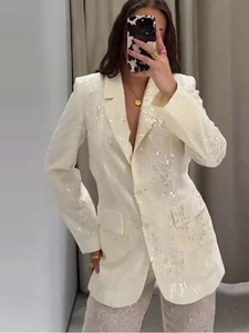 Dettaglio del blazer con paillettes color crema con trama riflettente e revers