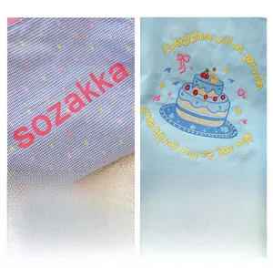 Close-up of contrast canvas tote featuring sweet birthday cake embroidery and logo print