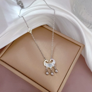 Detail view of silver long-life lock necklace with mother of pearl on a jewelry box