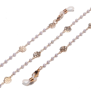 Modische goldene Brillenkette mit weißen Perlen und hohlen Rosenanhängern auf weißem Grund