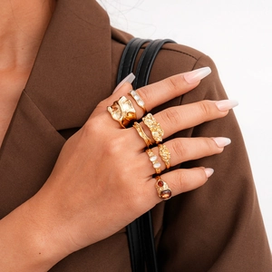 Detail of six-piece vintage gold ring set featuring irregular textures and resin gemstones