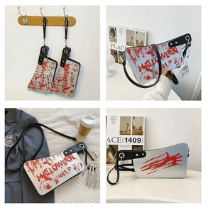 Detail of cleaver-shaped crossbody bag with blood splatter and skull charm accessory