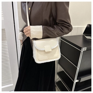 Detail showing cream PU leather crossbody bag with fuzzy wool trim and square buckle