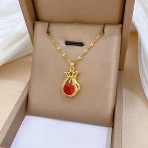 Makroaufnahme der goldenen Glücksbeutel-Halskette mit rotem Edelstein und Kristallen