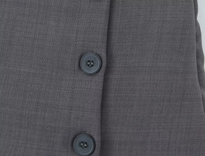 Dettaglio del tessuto twill grigio scuro con due bottoni in resina abbinati