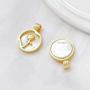 Macro detail of 18k gold plated white mother of pearl rose pendant on silk fabric