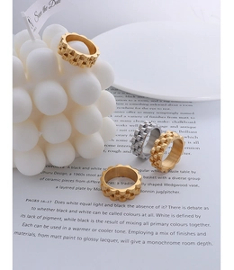 Detailed view of textured geometric 18k gold and silver titanium steel band rings