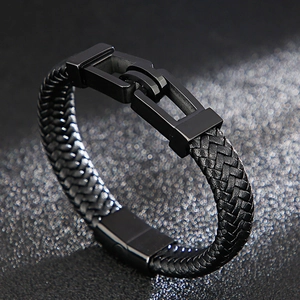 Detailed view of black braided leather bracelet with industrial style metal clasp