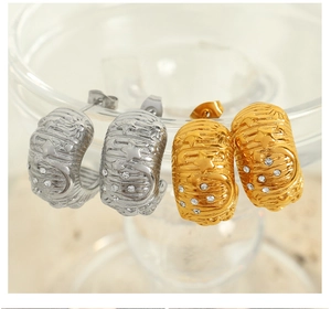 Detail showing gold and silver C-shaped earrings with embossed star moon and rhinestones