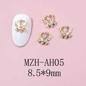 Macro detail of crown wing nail charm with pink marquise gem and gold base 8.5x9mm