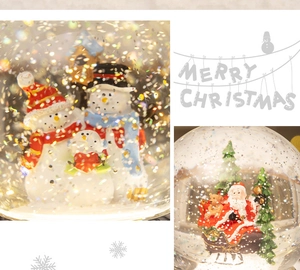 Detail of Christmas snow globe showing Santa on sleigh and snowman family inside