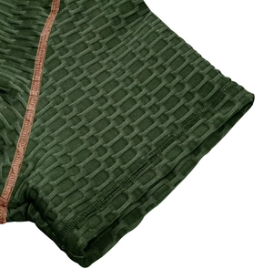 Gros plan sur le tissu gaufré vert olive et les coutures brunes du t-shirt henley sport