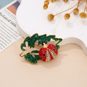 Elegant ladybug on leaf brooch with red enamel wings and sparkling crystal rhinestones