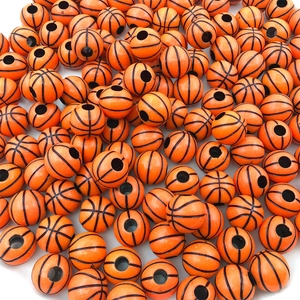 Macro shot of bulk orange acrylic basketball beads with black lines for DIY crafts