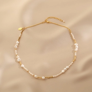 Baroque freshwater pearl necklace with gold metal tubes on elegant satin fabric