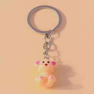 Close-up of a cute yellow cartoon bear keychain with pink accents and silver metal ring