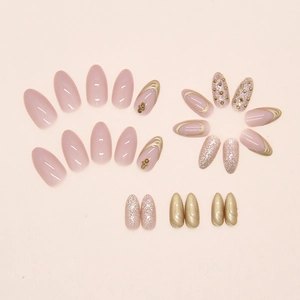 Detailed flat lay of champagne glitter almond press-on nails with gold rhinestones