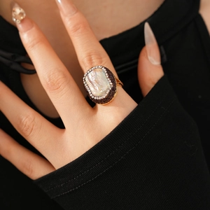 Macro shot of vintage gold-plated ring with baroque pearl and red crystal halo
