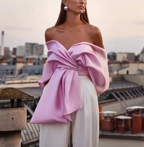 Détail du haut rose satiné à épaules dénudées avec nœud géant et pantalon large