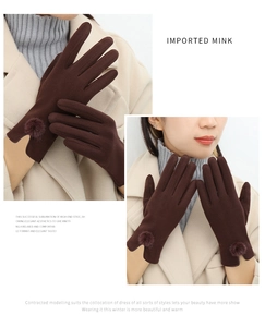 Detail of warm brown gloves with soft decorative pom-poms for winter style