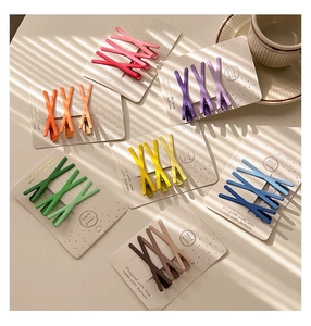 Close-up of matte candy-colored X-shaped hair clips set on display cards