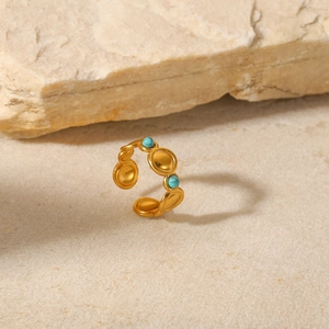 Gold bohemian stainless steel open ring with natural turquoise on a stone background